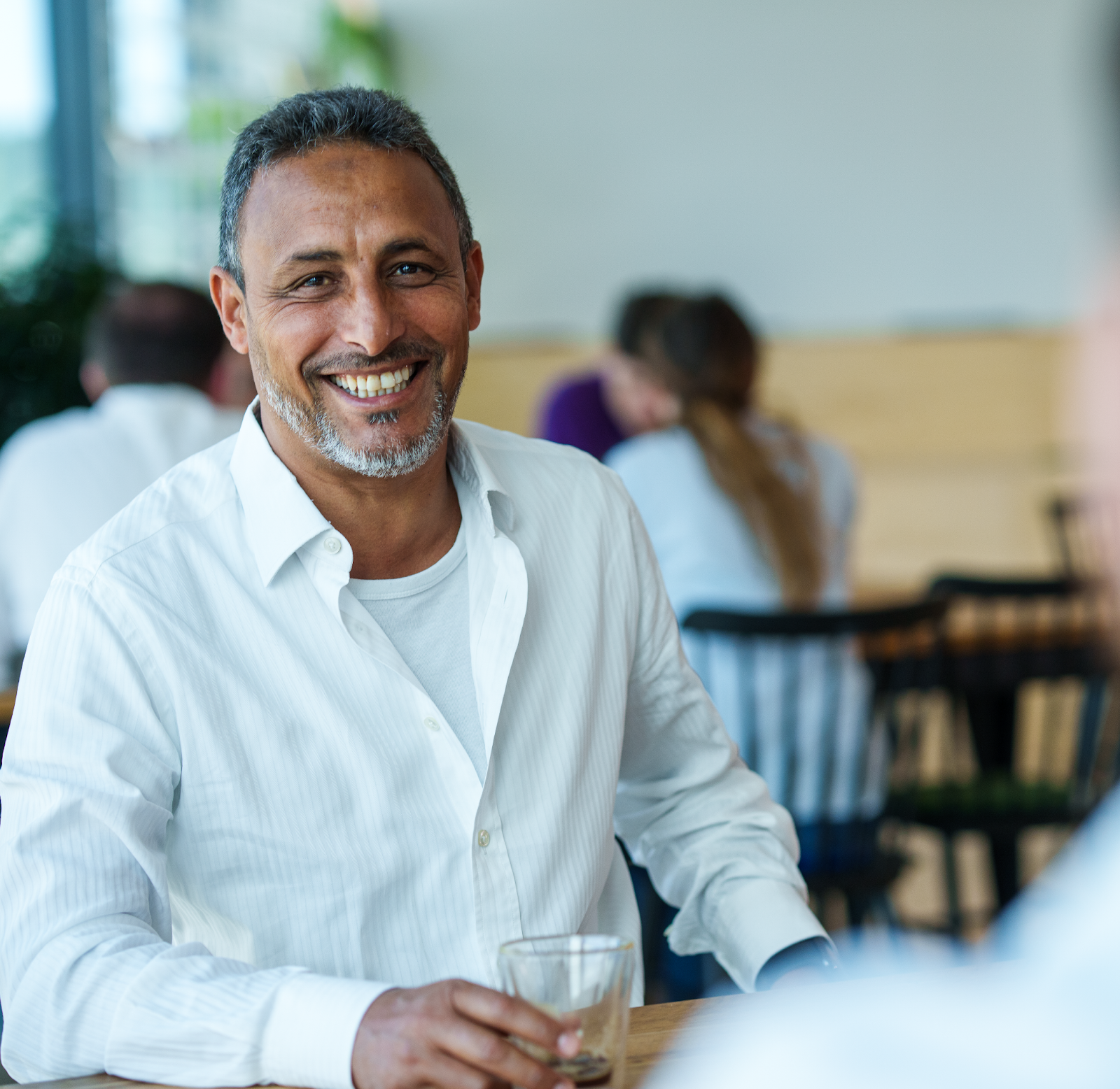 A smiling employee with a white shirt